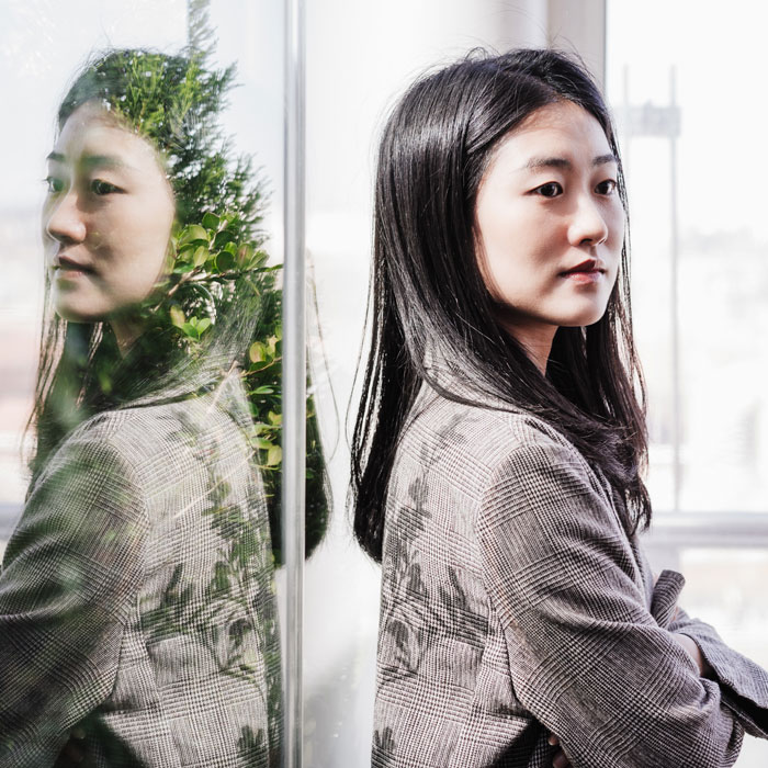 A woman and her reflection in a window